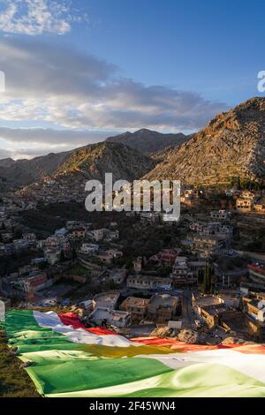 Akre, Irak. März 2021, 18th. Kurden setzen in der Altstadt von Akre eine Flagge Kurdistans über einen der Berge.die Stadt Akre im Gouvernement Duhok bereitet sich darauf vor, Nowruz (das persische Neujahr oder das kurdische Neujahr) zu feiern, indem sie Fahnen über den Bergen aufhängen. Das persische Neujahr oder das Kurdische Neujahr ist eine alte zoroastrische Tradition, die von Iranern und Kurden am 20th. März jedes Jahres gefeiert wird und mit der Frühlingstaquinoktikum zusammenfällt. (Foto: Ismael Adnan/SOPA Images/Sipa USA) Quelle: SIPA USA/Alamy Live News Stockfoto