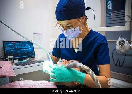 Zahnarzt, der ihre Patientin in ihrem Büro untersucht Stockfoto