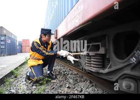 (210319) -- CHONGQING, 19. März 2021 (Xinhua) -- EIN Bahnangestellte überprüft einen Yuxin'ou (Chongqing-Xinjiang-Europa) China-Europa-Güterzug, bevor er den Tuanjie Village Station im südwestlichen Teil der Chongqing Gemeinde verlässt, 19. März 2021. Mit einer lauten Zugpfeife, die durch die Luft hallte, zog am Freitagmorgen ein Güterzug nach Duisburg langsam aus der Tuanjie Village Station der südwestlichen chinesischen Gemeinde Chongqing. "Vor genau einem Jahrzehnt signalisierte ich, dass Chinas erster China-Europa-Güterzug, der Yuxin'ou (Chongqing-Xinjiang-Europa), hier abfahren sollte, Stockfoto