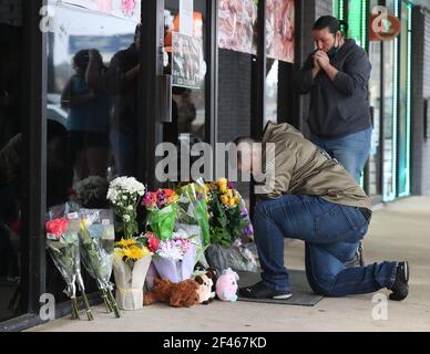 Acworth, USA. März 2021, 17th. US-Armeeveteran Latrelle Rolling, links, und Jessica lang, rechts, halten inne, um zu beten, nachdem sie Blumen bei Young's Asian Massage abgelassen hatten, bei der am Mittwoch, 17. März 2021, in Acworth, Georgia, vier Menschen getötet wurden. Mindestens acht Menschen wurden am Dienstag, den 16. märz 2021, von dem mutmaßlichen Mörder Robert Aaron Long in drei verschiedenen Spas in der Gegend von Atlanta tot aufgefunden. (Foto von Curtis Compton/The Atlanta Journal-Constitution/TNS/Sipa USA) Quelle: SIPA USA/Alamy Live News Stockfoto