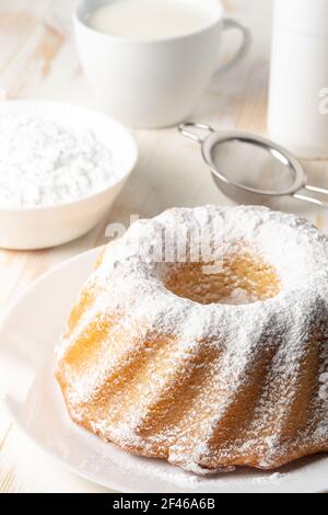 Hausgemachter Vanillekuchen auf weißem Holzhintergrund. Stockfoto