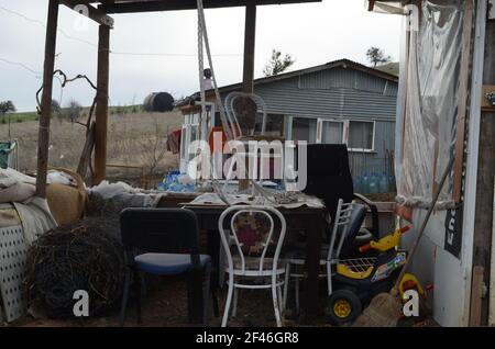 Der Garten eines schmutzigen, chaotischen Hauses voller Dinge. Hausbesetzer. Stockfoto