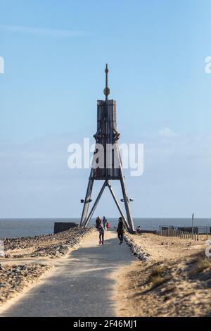 Tagesausflügler besuchen Kugelbake Beacon, Wahrzeichen der Stadt an der Elbmündung. Blick entlang des Fußweges auf den Wellenbrecher Stockfoto