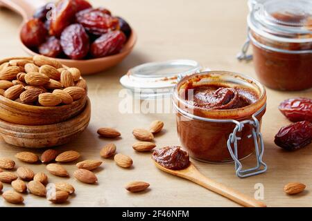 Vegane Datteln mit Mandeln (zuckerfrei) bestreuen. Krug mit hausgemachtem veganen Dattröpfchen. Stockfoto