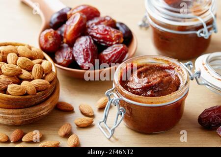 Vegane Datteln mit Mandeln (zuckerfrei) bestreuen. Krug mit hausgemachtem veganen Dattröpfchen. Stockfoto