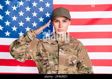 Portrait der ruhigen seriösen Dame Arm Kopf salutieren Grüße aussehen Fokussierte Kamera isoliert auf us-Flagge Stockfoto