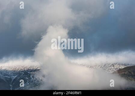 Atemberaubende Landschaft Bild von Skiddaw schneebedeckten Bergkette in Lake District im Winter mit niedrigen Wolken um Gipfel Stockfoto