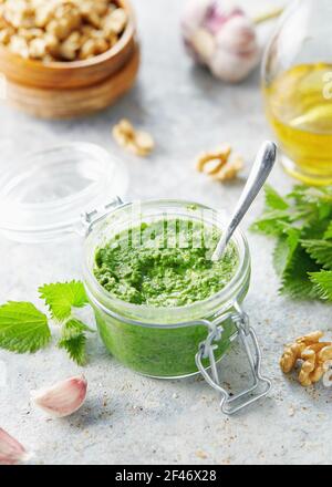 Vegetarische Brennnessel, Knoblauch und Walnusspesto. Nahaufnahme des Krug mit hausgemachtem Brennnesselpesto mit Walnüssen und Knoblauch. Stockfoto