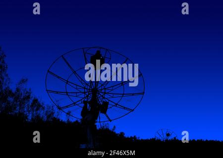 Radioteleskope Silhouetten unter dunkelblauem Himmel Hintergrund Stockfoto