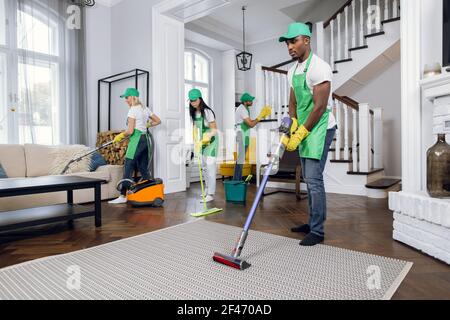 Gruppe von vier multirassischen Menschen Reinigung Client Haus Stockfoto