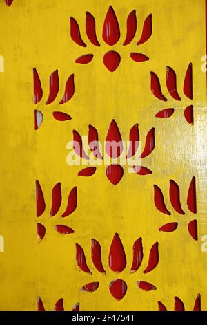 Eine vertikale Aufnahme einer gemusterten gelben Holzwand mit Rote Muster Stockfoto