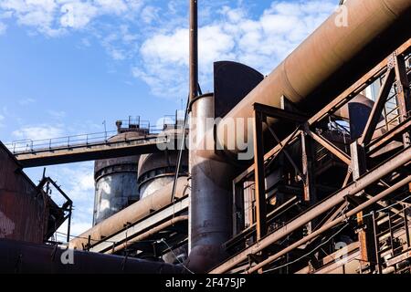 Blick auf eine alte Stahlmühle Anlage, Labyrinth von Rohren und Hochöfen, blauer Himmel, horizontaler Aspekt Stockfoto