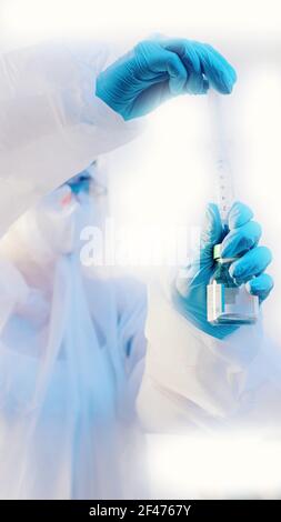 Nahaufnahme der Hände des Arztes in blauen medizinischen Handschuhen mit Coronavirus-Impfstoffflasche und Spritze zur Injektion im Labor. Hochwertige Fotos Stockfoto