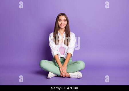 Foto-Portrait Ganzkörperansicht von niedlichen Mädchen sitzen in lotus Pose isoliert auf lebhaft lila farbigen Hintergrund Stockfoto