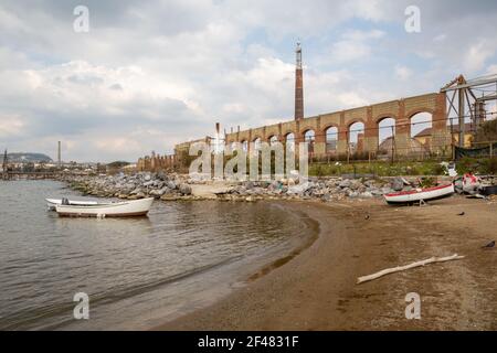 Napoli (Italien) - Bagnoli, Coroglio Strand, im westlichen Teil von Napoli, ex Bereich der ​​the Italsider Fabriken. Im Hintergrund die Überreste der "Stadt Stockfoto