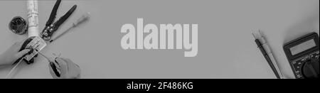 Elektriker schält die Isolierung von den Drähten ab - Nahaufnahme der Hände Und Zangen Stockfoto