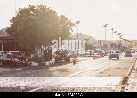 Blick auf die Straße in der Stadt Ägypten Sonnenuntergang. Großer Fahrzeugfluss. Asphaltstraße mit Laternen, auf denen Sonnenkollektoren installiert sind.Sommerlandschaft Stockfoto