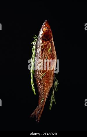 Gesmokter Hering auf schwarzem Hintergrund. Traditionelle Küche in den baltischen Landkreisen. Stockfoto