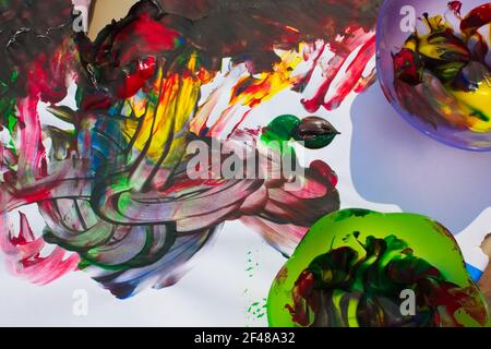 Horizontale Ansicht von oben des Kindes lebendige bunte Finger Malerei mit zwei Farbe Mischschüsseln. Stockfoto
