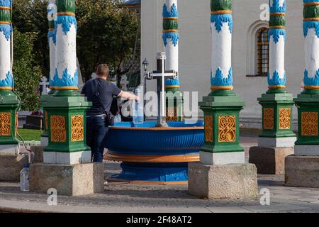 Die Gemeindemitglieder sammeln Wasser aus einer heiligen Quelle im Dreifaltigkeit-Sergius Lavra, Sergiev Posad, Russland Stockfoto