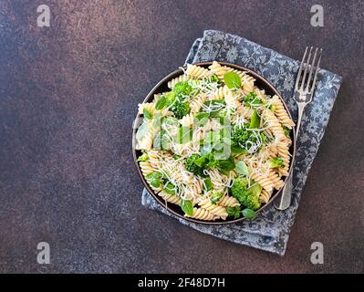 Fusilli mit Brokkoli, Basilikum und Parmesankäse auf dunklem Grund. Richtige Ernährung. Sporternährung. Diätmenü. Selektiver Fokus Stockfoto