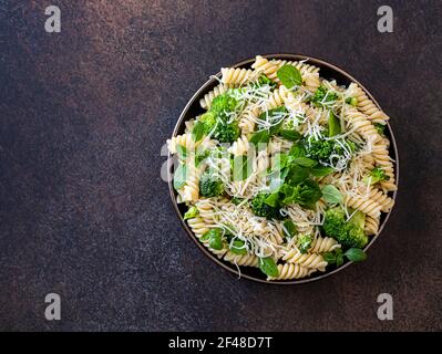 Fusilli mit Brokkoli, Basilikum und Parmesankäse auf dunklem Grund. Richtige Ernährung. Sporternährung. Diätmenü. Selektiver Fokus Stockfoto