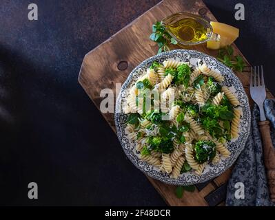 Fusilli mit Brokkoli, Basilikum und Parmesankäse auf dunklem Grund. Richtige Ernährung. Sporternährung. Diätmenü. Selektiver Fokus Stockfoto