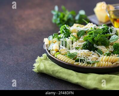 Fusilli mit Brokkoli, Basilikum und Parmesankäse auf dunklem Grund. Richtige Ernährung. Sporternährung. Diätmenü. Selektiver Fokus Stockfoto