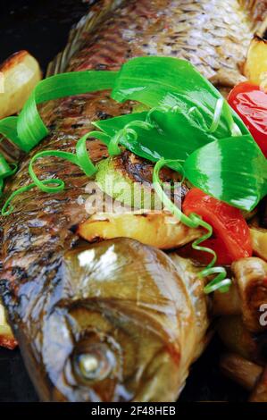 Gebackener Fisch mit Gemüse, Pilzen und Zitrone. Stockfoto