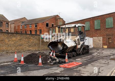 Asphaltwagen Vogele Straßenpflaster geparkt neben dem alten Bogenschützen Fabrik-Standort bereit für die Autobahnwartung in Trowbridge, Wiltshire, Großbritannien Stockfoto