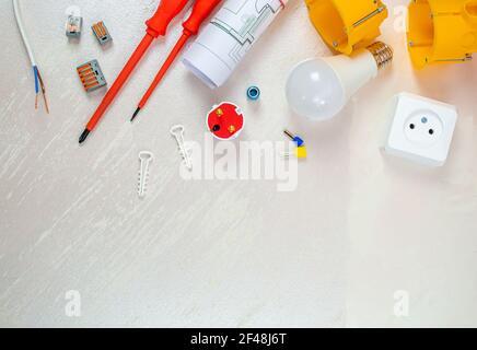 Flache Komposition mit Elektroinstallateur-Werkzeugen auf weißem Hintergrund. Für Text platzieren. Selektiver Fokus. Stockfoto