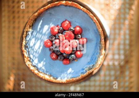 Beerennuss Käsekuchen auf einem Holzstuhl mit Sonnenschein, Nahaufnahme von oben Stockfoto