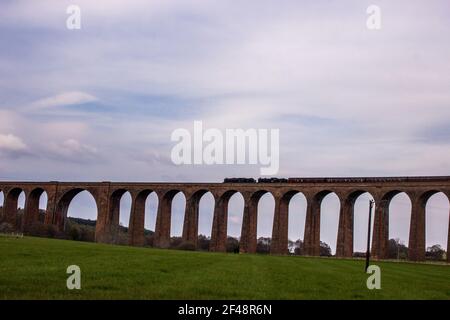 Ein Dampfzug, der das Viadukt von Culloden überquert, ein Eisenbahnviadukt, wo er den Fluss Nairn im Norden der schottischen Highlands überquert Stockfoto