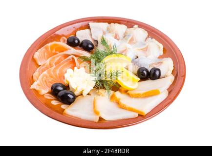 Köstliche Fischplatte. Lachs und geräucherter Stör mit Zitrone und schwarzen Oliven serviert. Isoliert auf weißem Hintergrund. Stockfoto