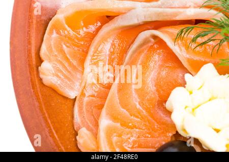 Lachs und Butter in Scheiben geschnitten auf dem Teller. Teil der Fischplatte Nahaufnahme. Makro. Foto kann als ganzer Hintergrund verwendet werden. Stockfoto