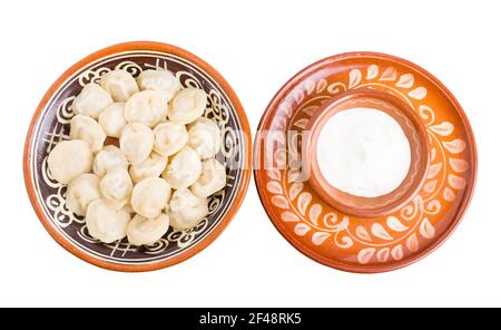 Russische Knödel Pelmeni mit Hackfleisch. Serviert mit saurer Sahne. Isoliert auf weißem Hintergrund. Stockfoto