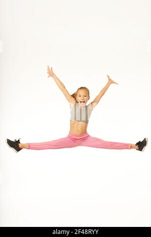 Fröhliche sportliche Mädchen springen und tun Splits in der Luft Stockfoto