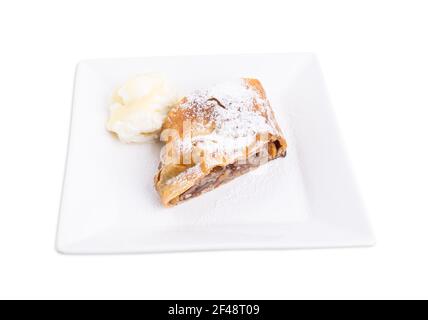 Köstlicher Strudel mit Apfel und Walnüssen. Serviert mit einer Kugel Vanilleeis. Isoliert auf weißem Hintergrund. Stockfoto