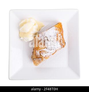 Köstlicher Strudel mit Apfel und Walnüssen. Serviert mit einer Kugel Vanilleeis. Isoliert auf weißem Hintergrund. Stockfoto