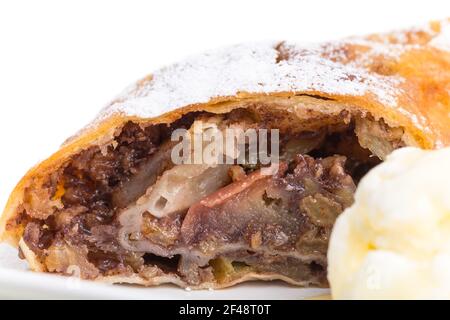 Köstlicher Strudel mit Apfel und Walnüssen. Serviert mit einer Kugel Vanilleeis. Makro. Foto kann als ganzer Hintergrund verwendet werden. Stockfoto