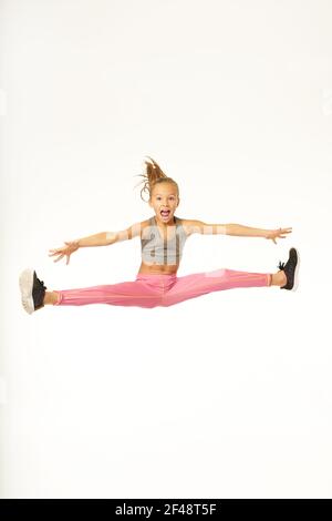 Liebenswert sportliche Mädchen springen und tun Splits in der Luft Stockfoto