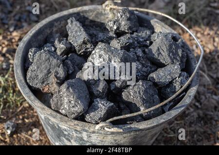 Heizung eines Wohnhauses im Dorf. Kohleeimer. Große Klumpen mineralischen Brennstoffs für Heizöfen und Heizkessel. Stockfoto