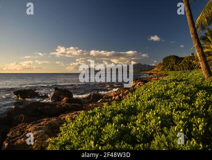 Spektakulärer Sonnenuntergang in Paradise Cove, Wellen des Pazifischen Ozeans, die auf vulkanischen Felsen entlang der idyllischen Küste, Kapolei, Oahu, Hawaii, USA, krachen Stockfoto