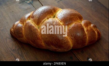 Ostern süßes Brot, tsoureki cosonac Laib auf Holz Tisch Hintergrund, Nahaufnahme. Brioche geflochten, challah. Festliche traditionelle Religion Dessert Stockfoto