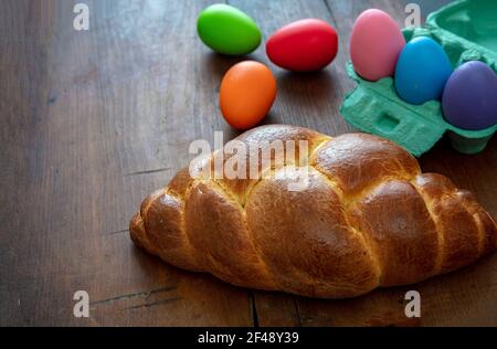 Vorlage für Ostern-Grußkarte. Orthodoxe ostern süßes Brot und bunte Eier, tsoureki cosonac Laib auf Holztisch Hintergrund, Festliche traditionelle reli Stockfoto