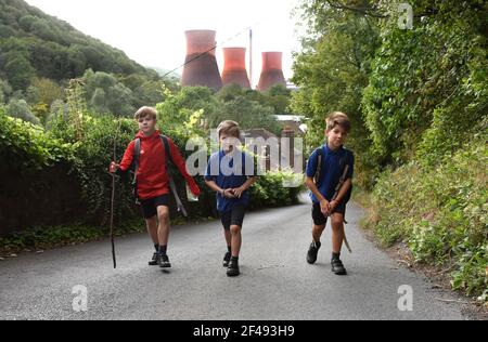 Nach Hause gehen von Schuljungen, die nach einem Schultag den Steep Hill hochlaufen. Schüler Kinder laufen nach Hause Steep Hill Britain UK. BILD VON DAVID BAGNALL Stockfoto