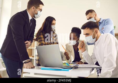 Diverse multiethnische Business-Team in Schutzmasken arbeiten in modernen Büro Stockfoto