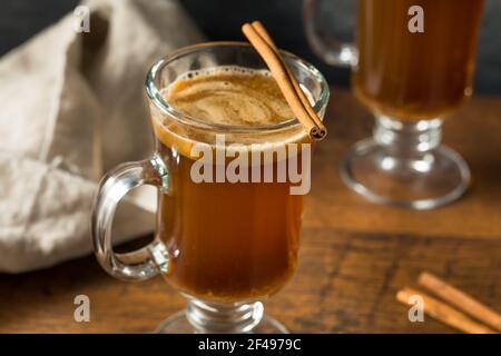 Hausgemachter Boozy Hot Buttered Rum mit Zimtstange Stockfoto