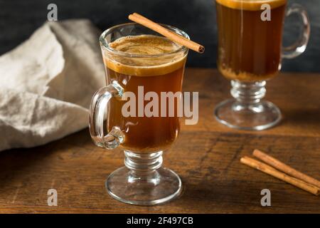 Hausgemachter Boozy Hot Buttered Rum mit Zimtstange Stockfoto