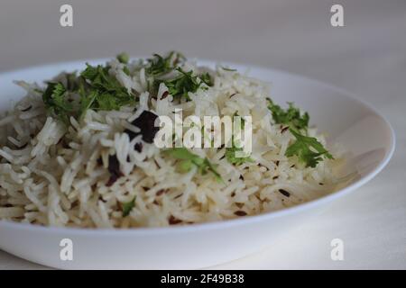 Gedämpfter Basmati-Reis mit Kreuzkümmel und Gewürzen. Lokal bekannt als Jeera Reis. Aufnahme auf weißem Hintergrund Stockfoto